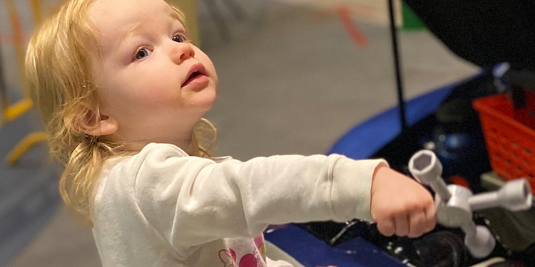 Kid playing as car maintenance person at museum