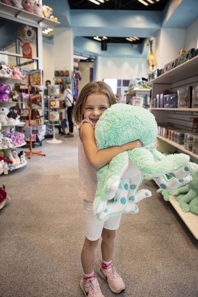 Girl holding Plushy toy at the Red Ballon Toy Store