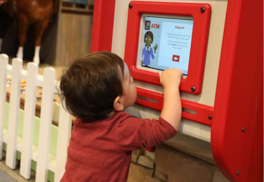 Kid interacting with model ATM machine